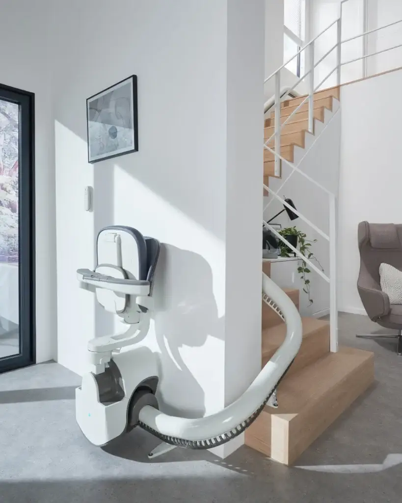 Flow X chair folded beside a modern white staircase